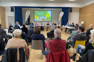 Bürgerbefragung in einem großen Saal mit vielen interessierten Teilnehmer:innen